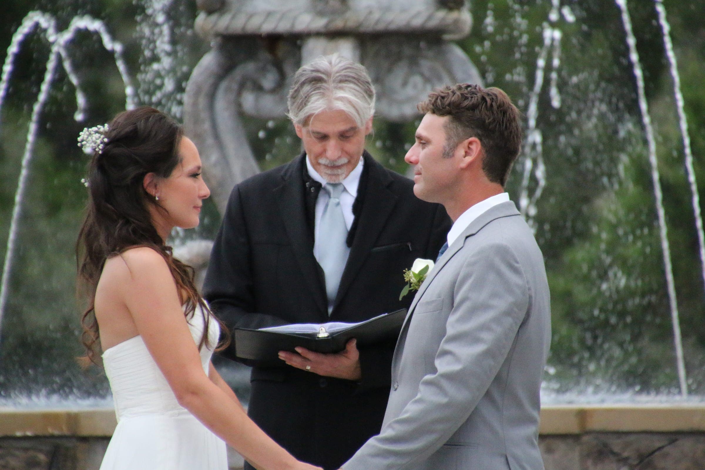 Bride and groom exchanging vows at the stone fountain