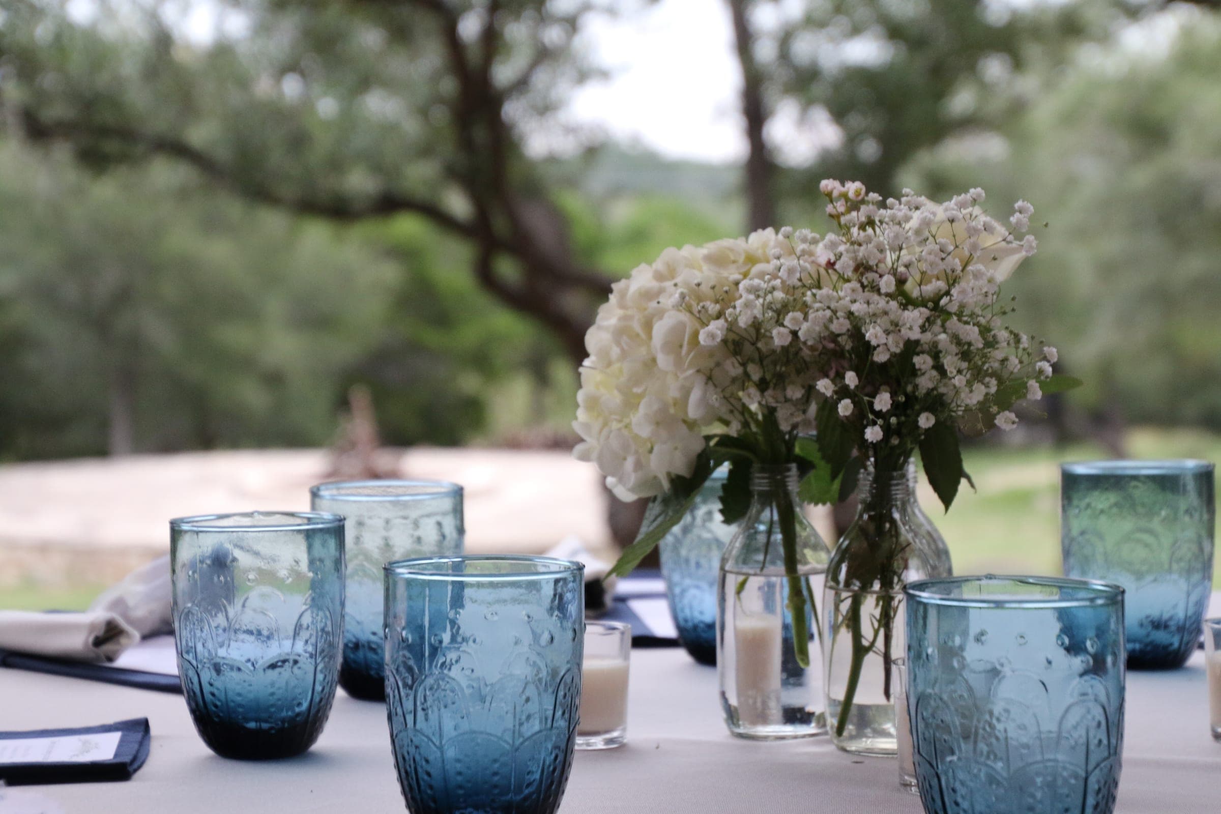 Table setting with blue glassware and white florals