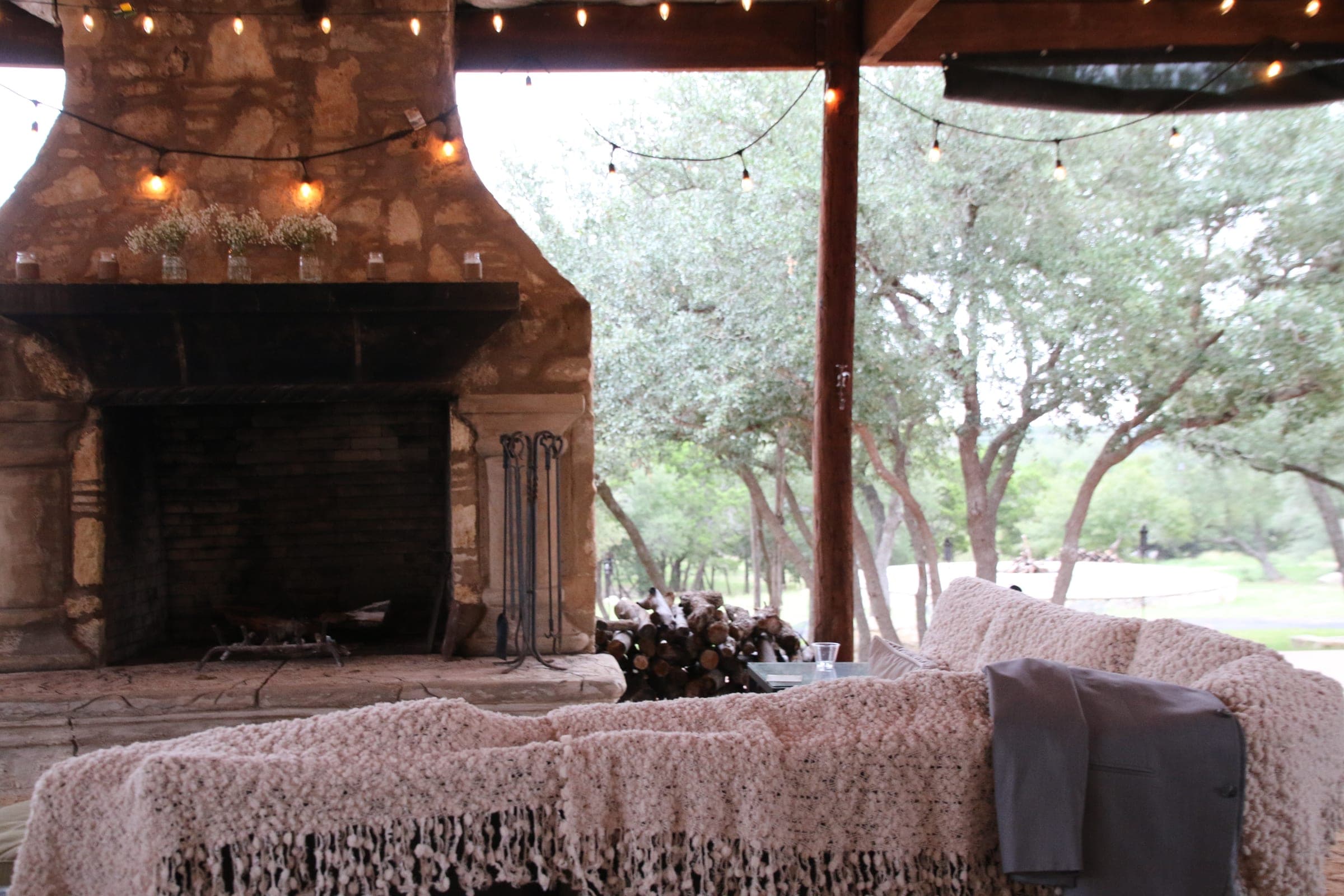 Stone fireplace lounge strung with string lights